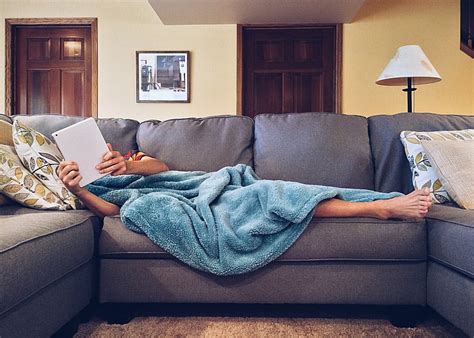 Royalty Free Photo Person Covered With Blue Blanket Lying On Gray Sofa