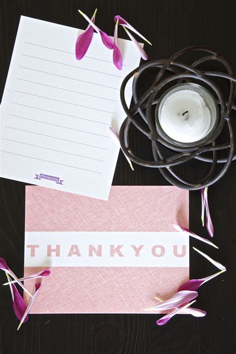 A Thank You Card With Pink Flowers And A Candle On A Wooden Table Next