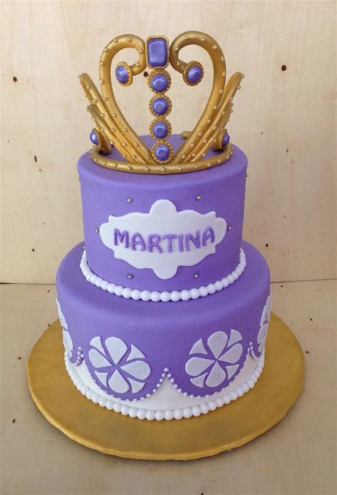 There Is A Purple Cake With Gold Crown On Top And Mardi Gras Decorations