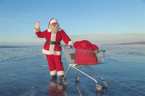 Santa Claus Carries A Shopping Cart With Ts In A Sack Stock Image