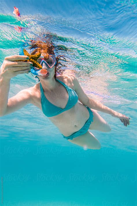 Woman In Bikini Holding Starfish Swimming Underwater At All Inclusive Caribbean Resort White