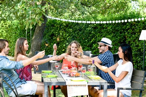 Group Of Friends Having Fun Picnic Lunch Party Outdoor In Backyard