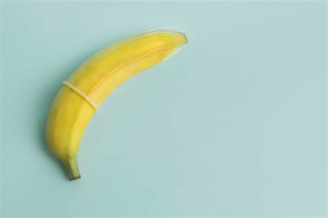 성교육과 안전한 섹스 피임에 있는 페니스의 바나나와 콘돔 개념 프리미엄 사진