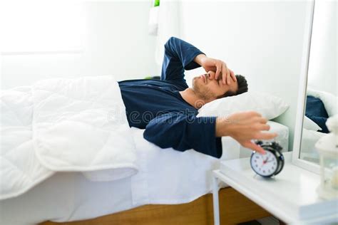 Tired Man Waking Up By The Sound Of The Alarm Stock Photo Image Of