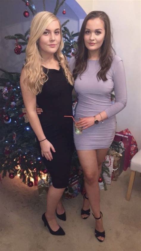 Two Women Standing Next To Each Other In Front Of A Christmas Tree