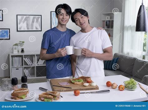 Asian Gay Couple Cooking On Kitchen And Looking At Camera Lgbt Men Couple Are Having Fun