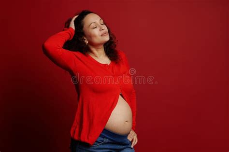 fashion portrait of multi ethnic beautiful pregnant woman posing with closed eyes and bare