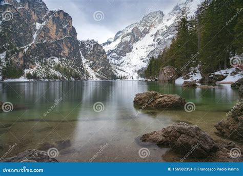Long Exposure At Braies Lake And Dolomite With Snow In A Cloudy Day