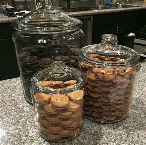 Three Glass Jars Filled With Cookies On Top Of A Counter
