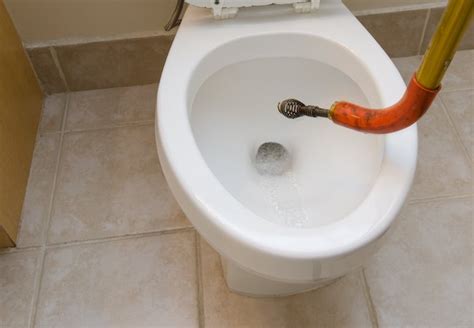 Give it one good push. How To Snake a Toilet - Bob Vila