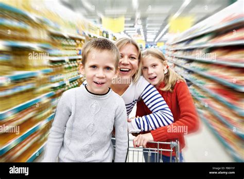 Happy Women And Children With Cart Shopping In Supermarket Stock Photo