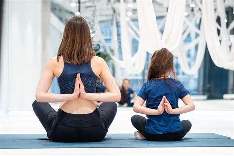 Young Adult Mother And Little Daughter Together Practicing Yoga Stock