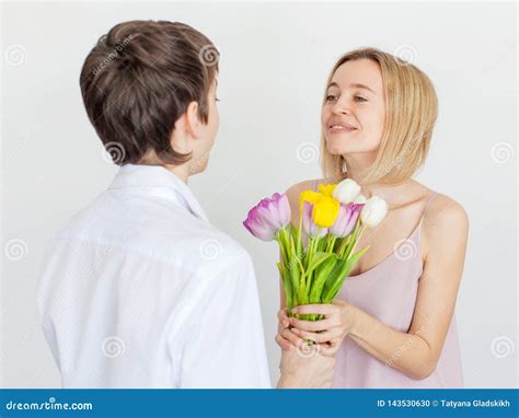Son Gives Mom A Bouquet Of Flowers For The Holiday Stock Photo Image