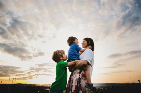 Mamá Abraza Con Sus Dos Pequeños Hijos Tiernos De Pie En Los Rayos