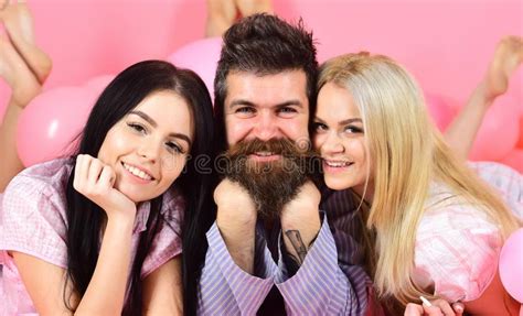 girls fall in love with bearded macho pink background threesome on smiling faces lay near