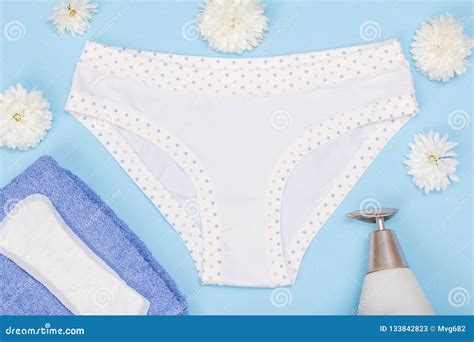 beautiful women`s panties with a sanitary napkin and towel on blue background stock image