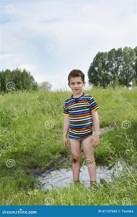 Dirty Rural Boy Stands Barefoot In A Puddle Stock Photography Cartoondealer
