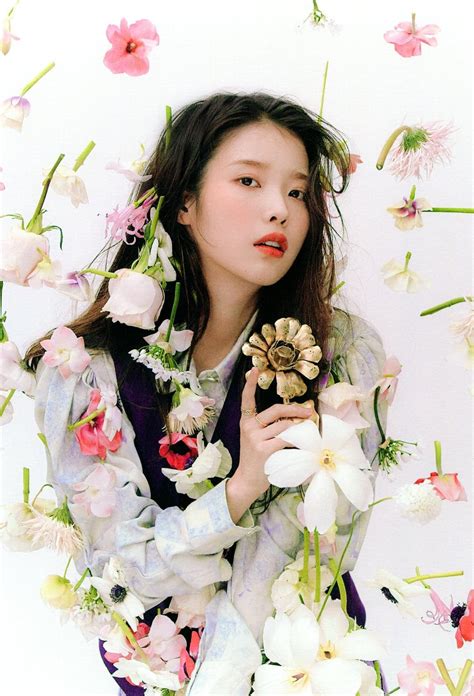 A Woman With Flowers Around Her Neck Holding A Flower