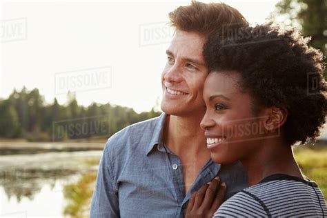 Happy Mixed Race Couple Admiring A View In The Countryside Stock