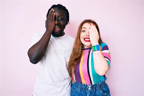 Interracial Couple Wearing Casual Clothes Covering One Eye With Hand