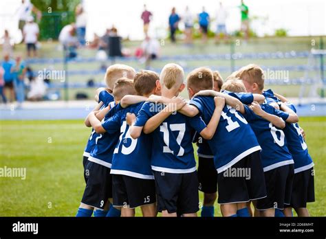 Boys Football Team Forming Huddle Happy Kids In A Sports Team On Grass