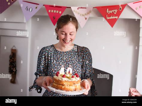 a woman celebrates her 40th birthday by blowing out the candles on her birthday cake in armoy