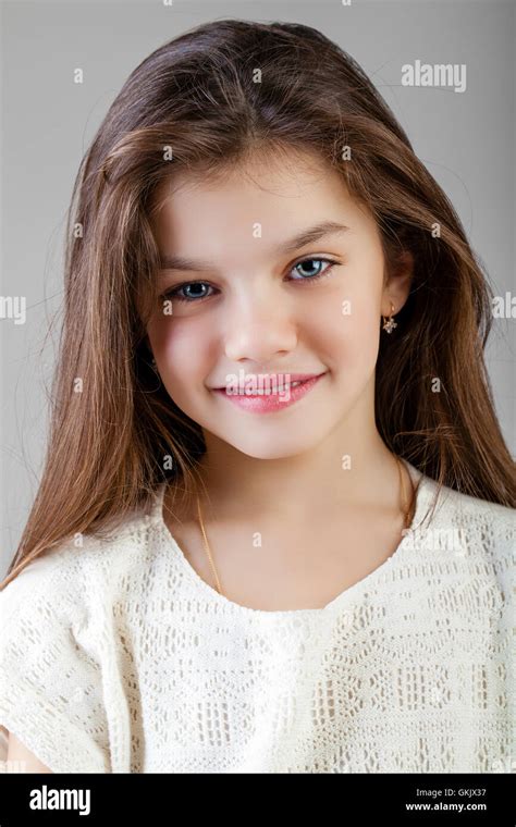 Portrait Of A Charming Brunette Little Girl Isolated On Gray
