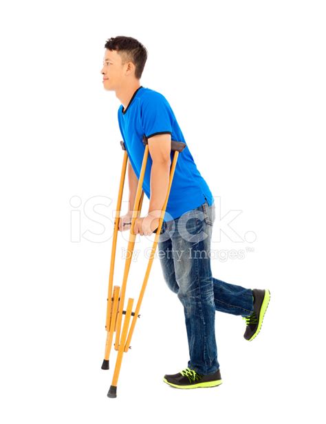 Full Length Of Young Asian Man On Crutches White Background Stock