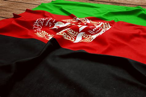 나무 책상 배경에 아프가니스탄의 국기입니다 실크 아프간 플래그 보기 가기 아프가니스탄 국기에 대한 스톡 사진 및 기타 이미지