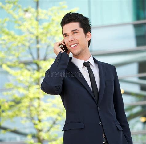 Portrait Of A Handsome Businessman Talking On Mobile Phone Outdoors