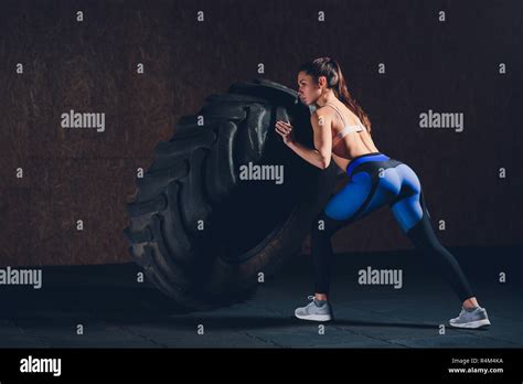 Fitness Woman Flipping Wheel Tire In Gym Fit Female Athlete Working