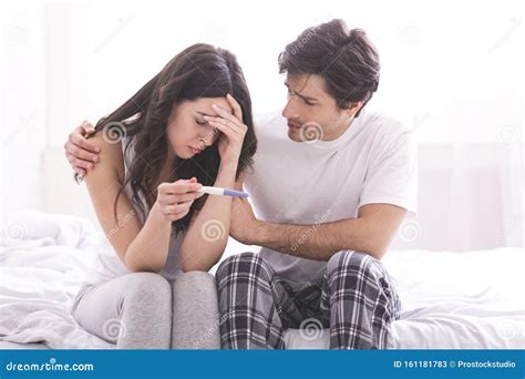 Upset Man Comforting His Depressed Wife With Negative Pregnancy Test