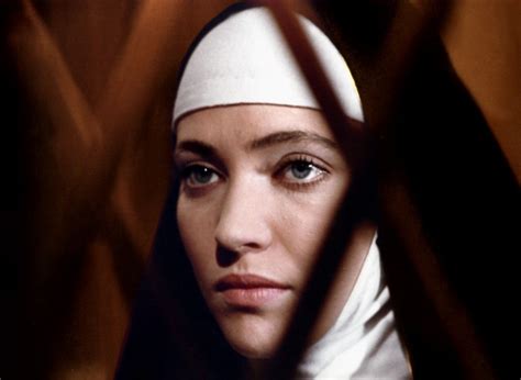 A Woman Wearing A Nun S Headdress Behind Bars