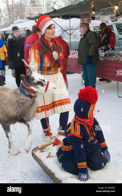 Traditional Reindeer Caravan With People Dressed In Same Folk Costume