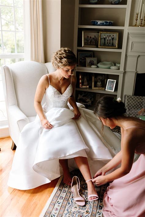 Bride Getting Dressed On Her Wedding Day Sweet Moment With Sister Putting On Her Shoes Bride