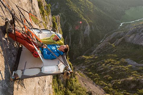 Rock Climbing Couple Laying Down On Their Portaledge By Stocksy