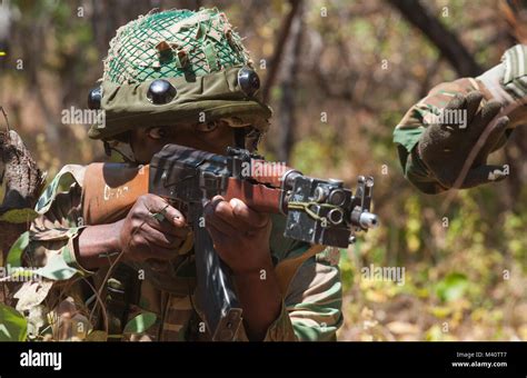 A Member Of The Zambian Defense Force Draws His Weapons During A