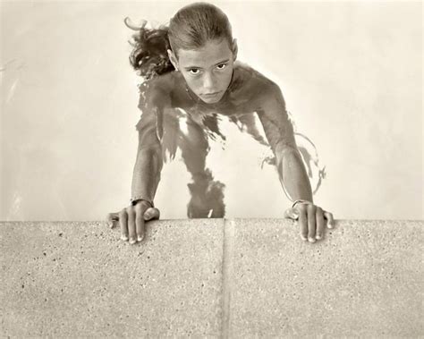 An Old Photo Of A Woman Leaning On A Wall With Her Hands Behind Her Head