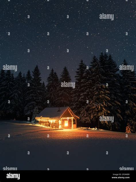 Fantastic Winter Landscape With Wooden House In Snowy Mountains Starry