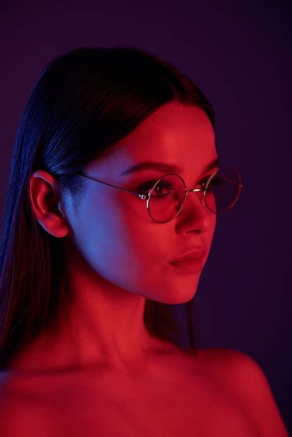 Premium Photo Side View Of Serious Naked Woman In Round Glasses Under Neon Light In Dark Room