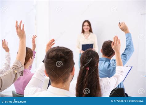 People Raising Hands To Ask Questions At Business Training Stock Photo
