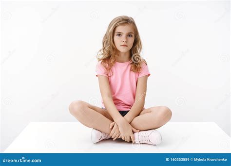 Serious Indifferent Cute Blond Little Girl Sitting On Floor Legs