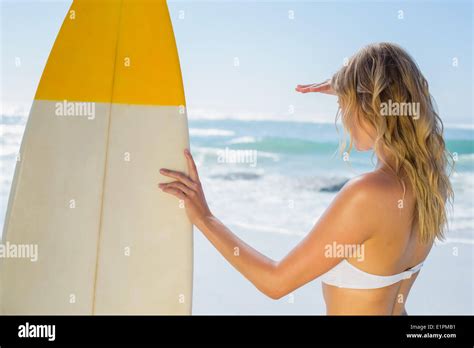 Blonde Surfer In White Bikini Holding Her Board On The Beach Stock