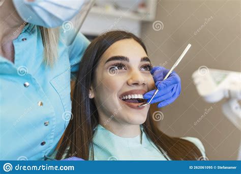 Portrait Of Female Patient Having Treatment At Dentistdentist Examining A Patient`s Teeth In