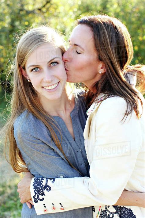Close Up Of Mother Kissing Cheek Of Daughter Stock Photo Dissolve