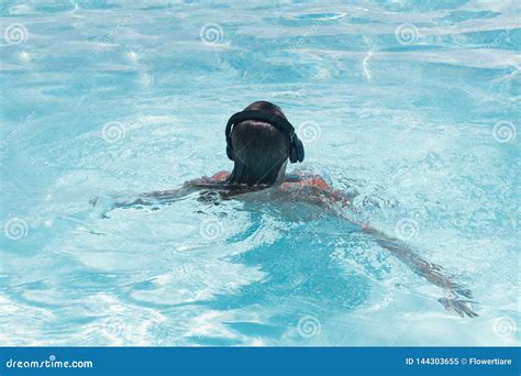 woman in the headphones listening to the music bathing in a pool stock image image of hotel