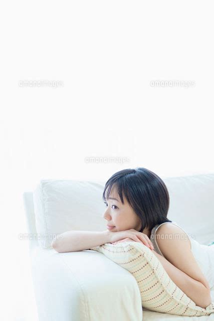 ソファに寝転ぶ女性 10272001926 の写真素材イラスト素材アマナイメージズ