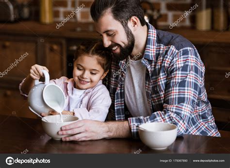 Padre Hija Vertiendo Leche Tazón Con Bocadillos Cocina Fotografía De