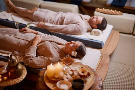 Couple Lying Down On Massage Beds In Spa And Wellness Center Stock