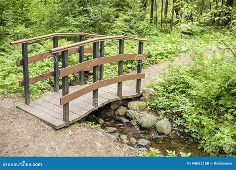 Trail Leads To A Small Wooden Bridge Over A Creek In The Woods Stock